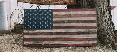 "Rustic wooden American flag with distressed red, white and blue finish displayed outdoors - Flags of Valor patriotic home decor