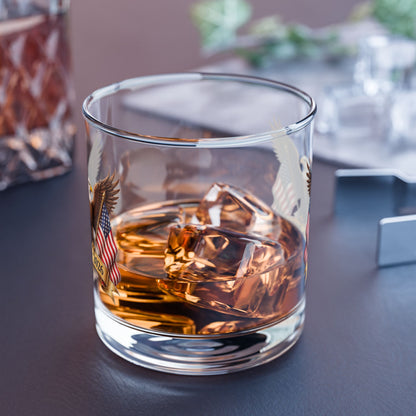 Glass of whiskey with ice cubes on a dark surface