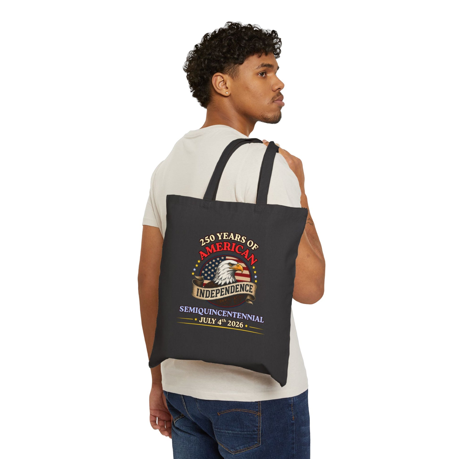 Man carrying an America 250 independence eagle canvas tote bag in black canvas, vintage Americana eagle print, 15x16