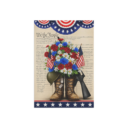 Decorative flag with American flags, flowers, boots, and a gun on a 'We the People' background.