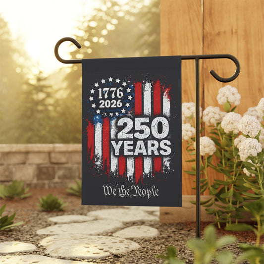 Garden flag with 1776-2026 design and  We the People text on a stand outdoors.