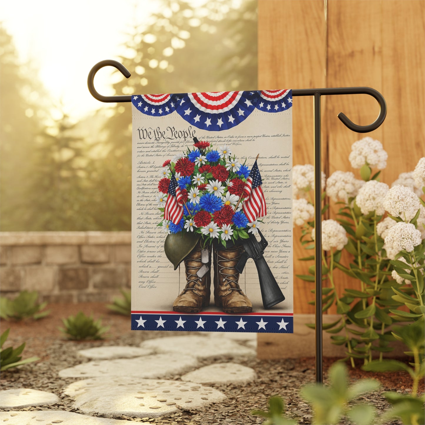 Decorative garden flag with boots, flowers, and American flags on a stand outdoors.