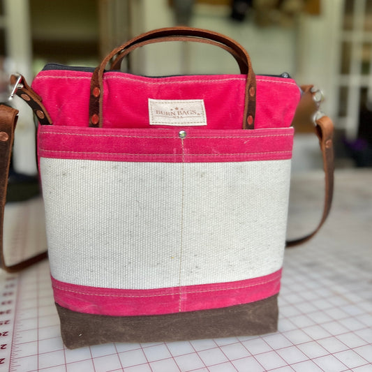 Peony Pink Engineer Burn Bag made from waxed canvas and decommissioned fire hose with reinforced front panel and leather carry straps.