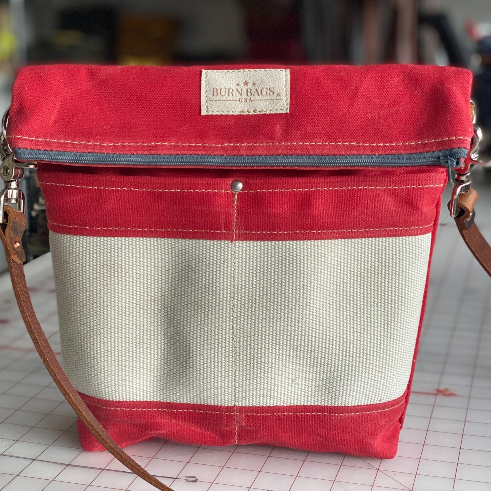 Engine Red Crossbody Burn Bag with decommissioned fire hose panel and leather strap