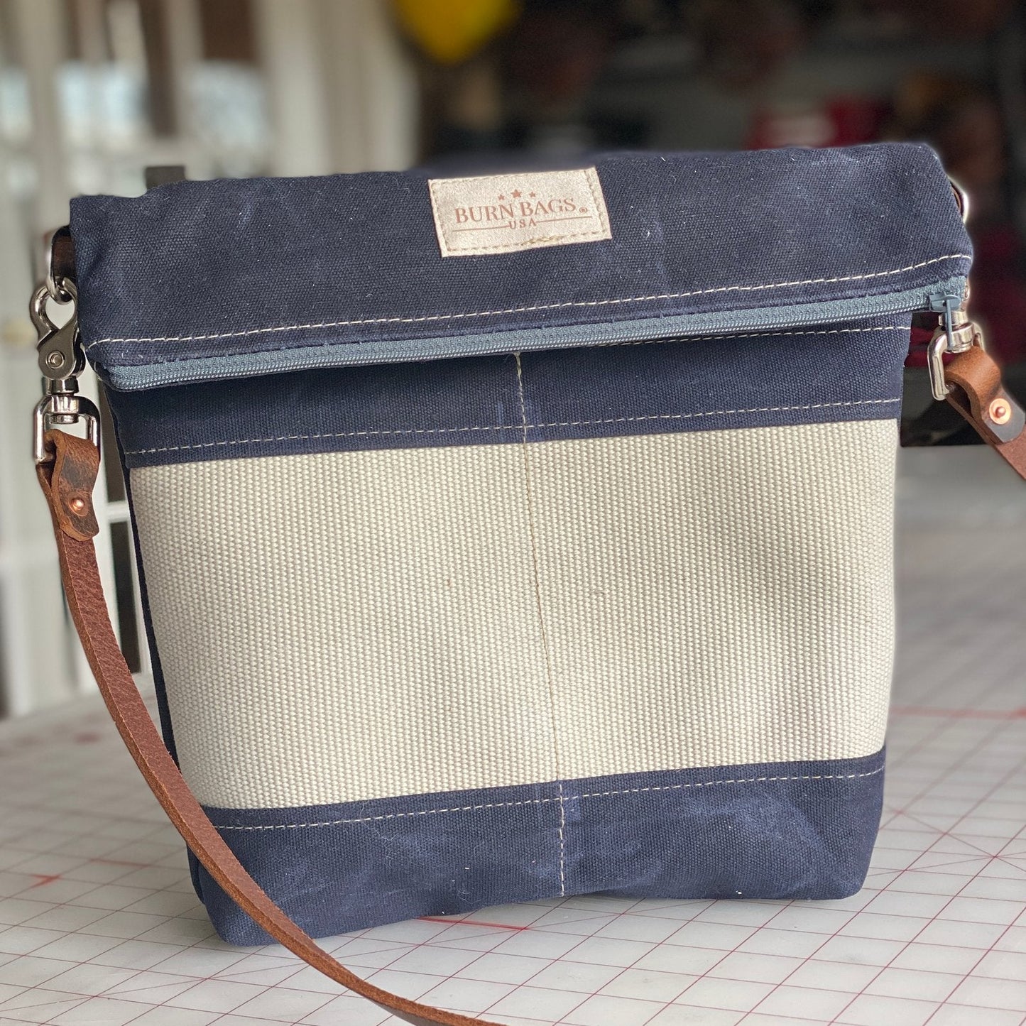 Navy Crossbody Burn Bag made from decommissioned fire hose with leather strap