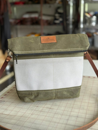 Olive Green Crossbody Burn Bag made from decommissioned fire hose with fold-over design and 48-inch water buffalo leather strap.