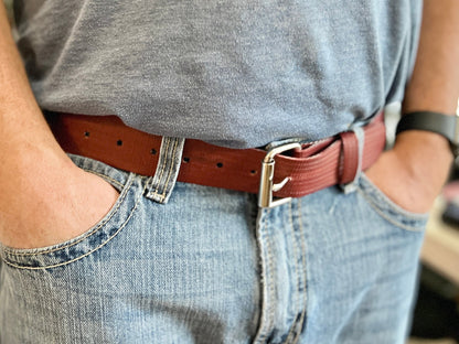 Red Rubber Fire Hose Belt made from repurposed fire hose with metal buckle and visible hose texture.