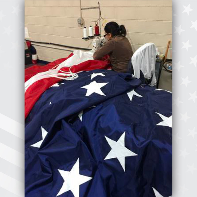 Lady sewing a massive American flag in at Eder Flag.