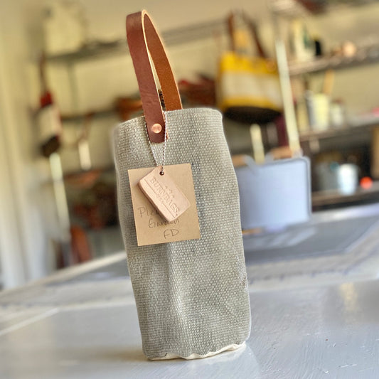 Burn Bag Wine Carrier made from decommissioned fire hose and waxed canvas with a reinforced handle.