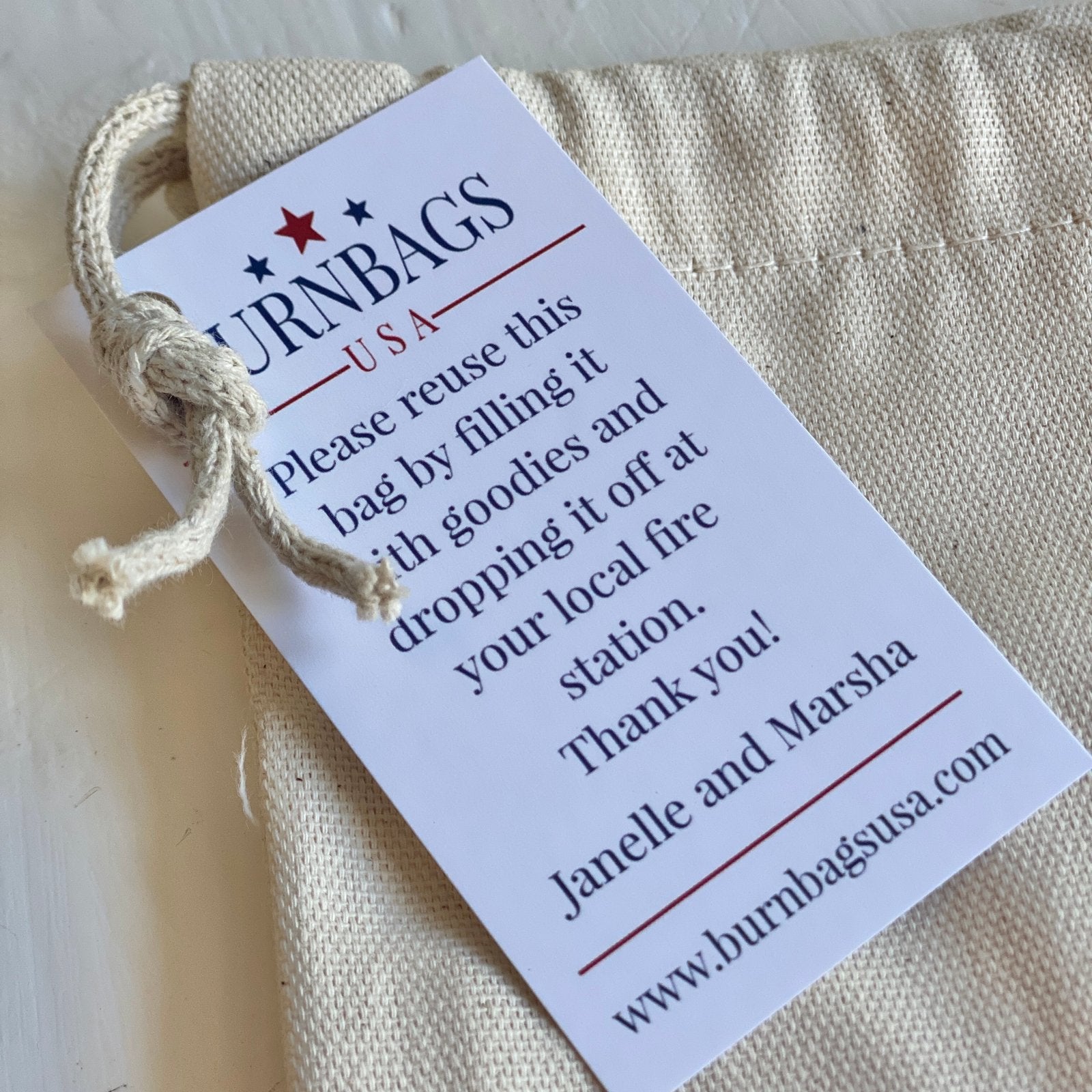 Close-up of the authenticity card attached to the Wine Carrier, showing the fire hose origin information and stitching detail.