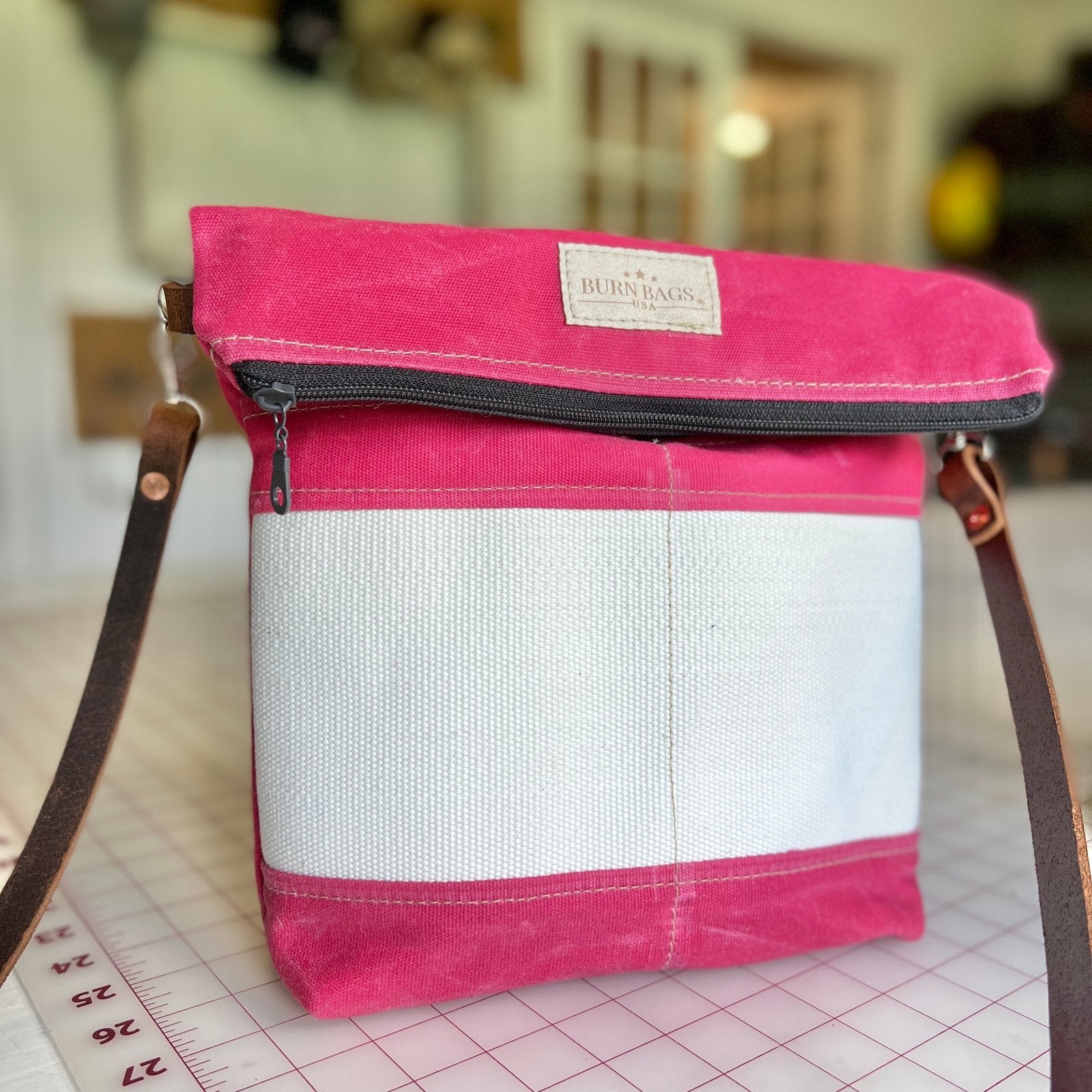 Peony Pink Crossbody Burn Bag made from decommissioned fire hose with fold-over design and a 48-inch leather strap.