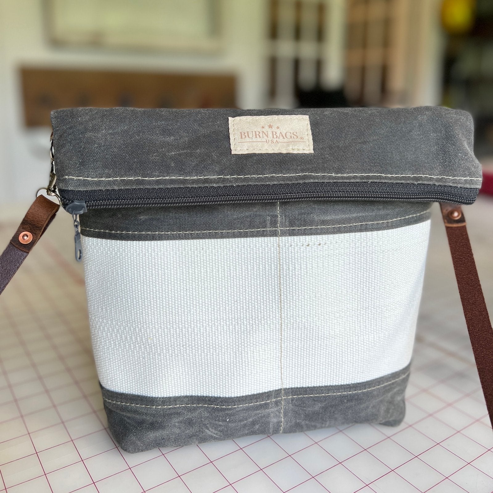 Charcoal Gray Crossbody Burn Bag made from decommissioned fire hose with fold-over design and 48-inch water buffalo leather strap.