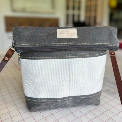 Charcoal Gray Crossbody Burn Bag made from decommissioned fire hose with fold-over design and 48-inch water buffalo leather strap.