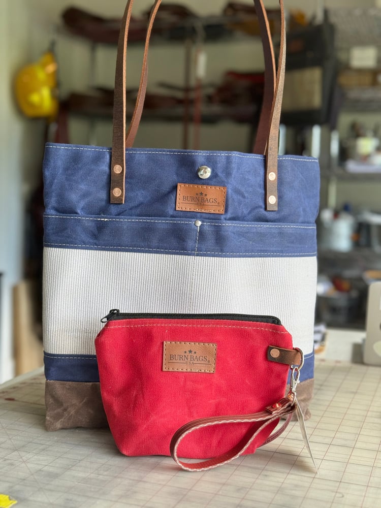 Navy Blue Classic Burn Bag displayed with a red waxed canvas pouch made from reclaimed fire hose.