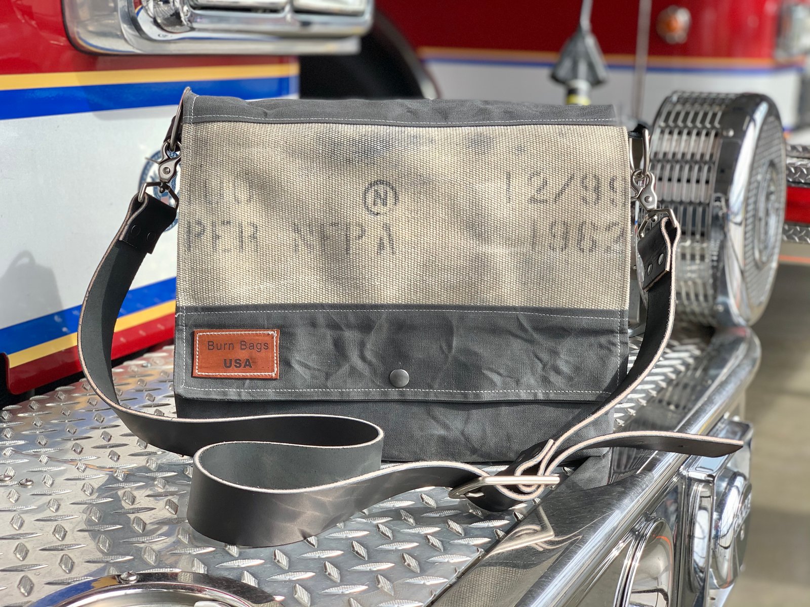 Charcoal Gray Messenger Burn Bag made from decommissioned fire hose and waxed canvas with a messenger-style flap and adjustable leather strap.