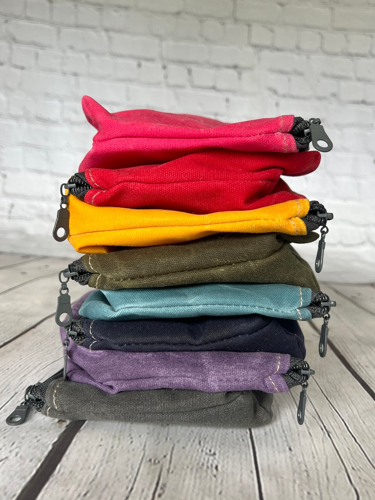 Stack of Rubber Fire Hose Clutches in multiple colors, each with detachable fire-hose wristlet.