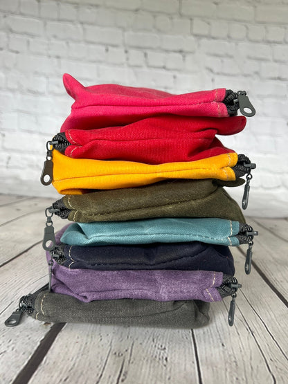 Stack of Rubber Fire Hose Clutches in multiple colors, each with detachable fire-hose wristlet.